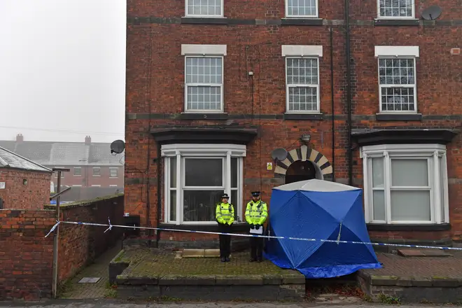 Police officers outside a three-storey block of flats in Stafford as they search a property.