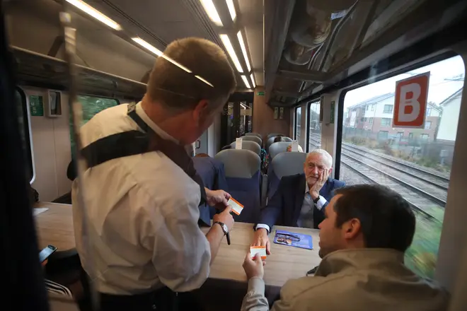 Jeremy Corbyn has his tickets checked on a train