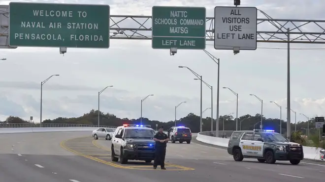 Police vehicles block the entrance to Naval Air Station Pensacola