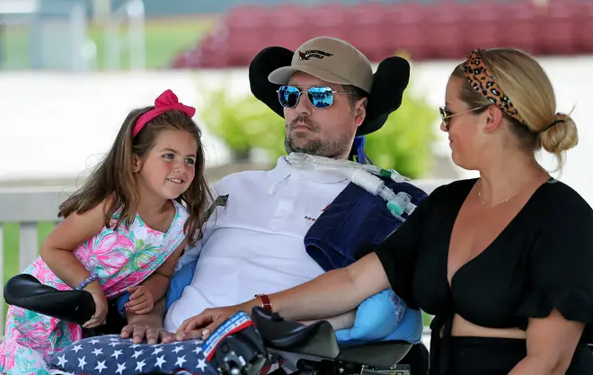 Pete Frates, centre, sits with his four-year-old daughter Lucy and wife Julie at a dedication ceremony at Boston College.