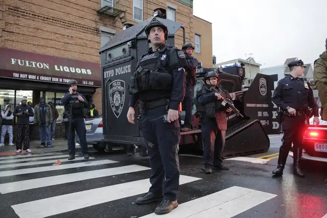 Emergency responders move heavy equipment near the scene of a shooting in Jersey City, N.J.