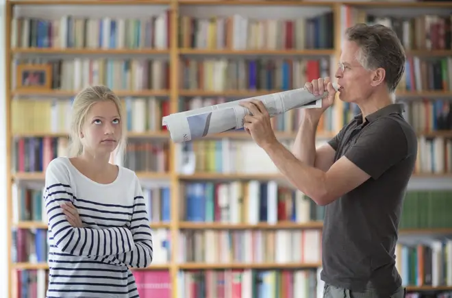 A parent tries to speak to his teenage daughter through a megaphone