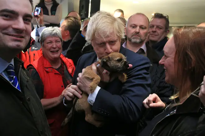 Mr Johnson kisses a dog he is handed at the event