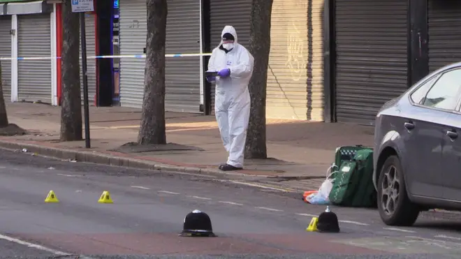 Forensics officers work at the scene