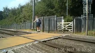 Children balance on railway tracks in dangerous act.