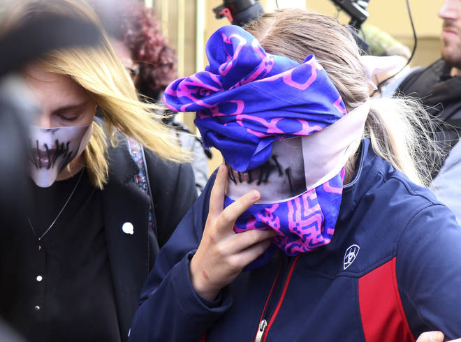 A 19-year-old covers her face after a Cyprus court deemed she lied about being gang raped