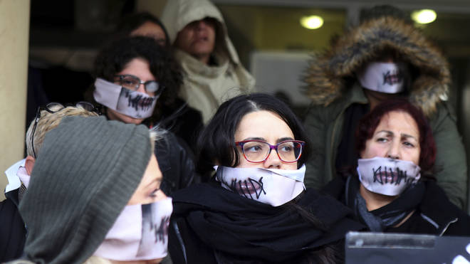 Protestors had masks which showed their lips being sewn together as they gathered in protest