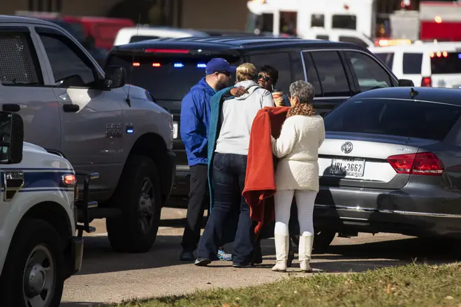 Family and friends comfort each other outside the scene