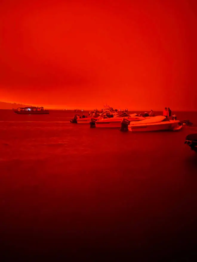 A blood-red sky is seen across the coast as residents flee to boats