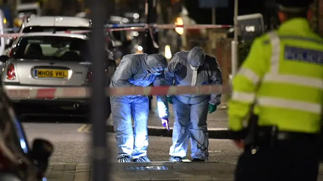 A forensics team examines the murder scene in north London