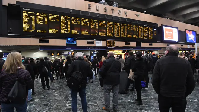 Commuters wait for trains at Euston station in London
