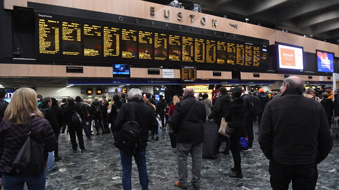 Commuters wait for trains at London's Euston station