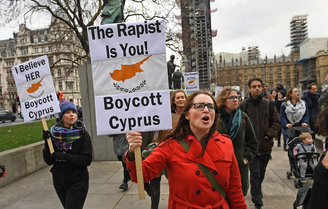 Demonstrators walk past the Houses of Parliament in central London, as they take part in a protest march in support of the British woman convicted in Cyprus of lying about being gang-raped.
