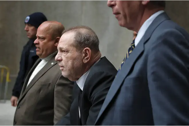Harvey Weinstein, third from left, leaves court in New York.