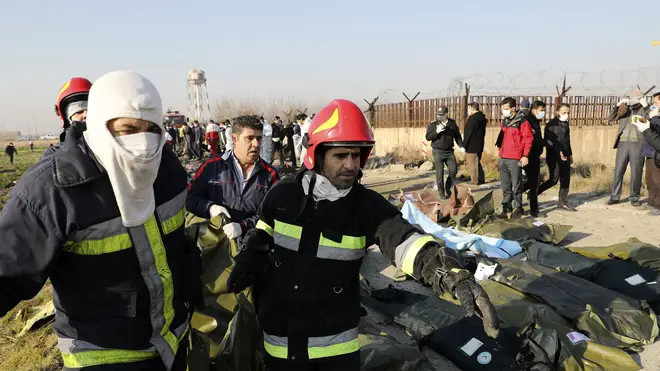 Rescue workers carry bodies away from the crash