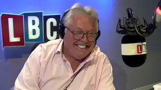 Nick Ferrari smiles as he listens to a very angry caller