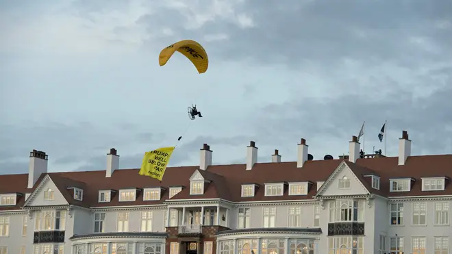 A Greenpeace protester flies within metres of President Trump at his Turnberry resort.