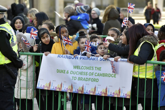 Schoolchildren gather to see the royal couple