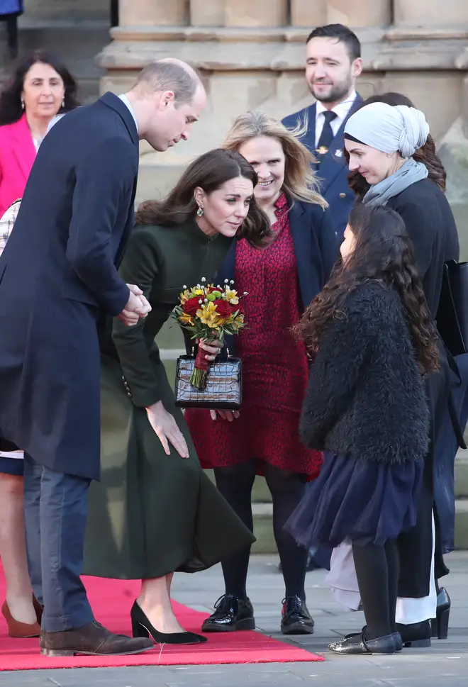 Kate is given a bunch of flowers by a young girl