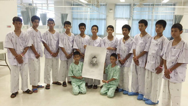 The 12 rescued boys in hospital holding a sketch of Thai Nave SEAL who died in their rescue attempt.