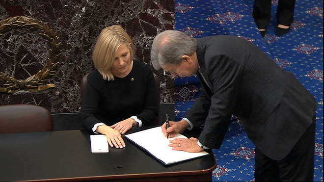 Senators were called up one by one to sign the oath book