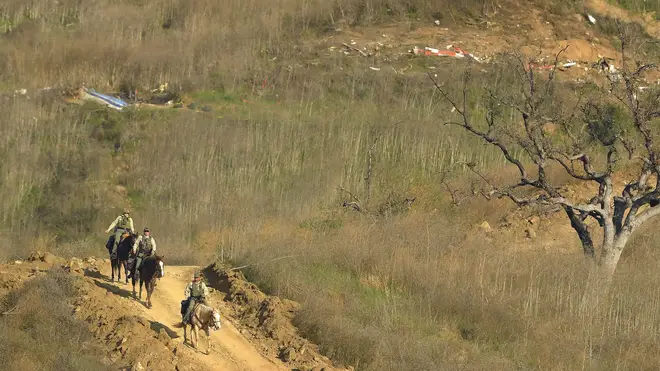Police officers on horseback are patrolling the area to deter looters