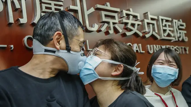 A medical worker being sent to Wuhan kisses goodbye to his partner