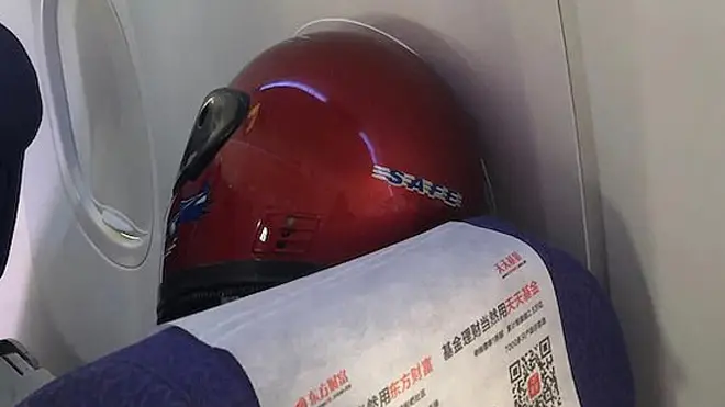 The man was seen on board the nine-hour flight wearing a crash helmet