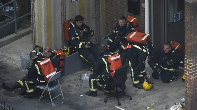 Firefighters rest after going into burning building