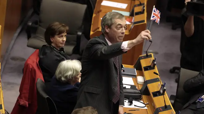 Nigel Farage waves a Union flag as he leaves the chamber in Brussels