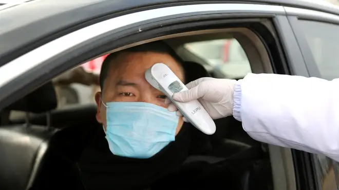 Chinese citizens are temperature checked at checkpoints