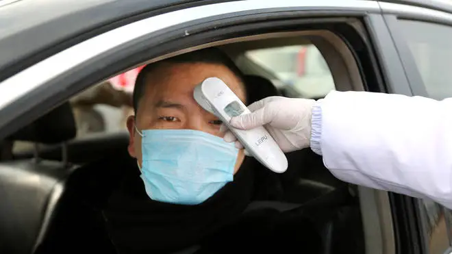 Chinese citizens are temperature checked at checkpoints