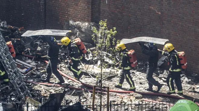 Riot police protect firefighters from falling debris