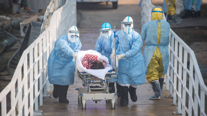 Medical workers help the first batch of patients infected with the novel coronavirus move into their isolation wards at Huoshenshan Hospital in Wuhan