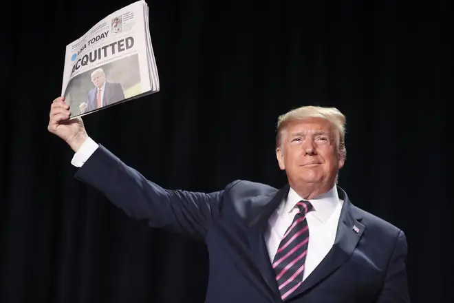 Mr Trump held up newspapers with the headlines 'Acquitted'