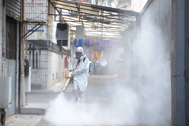 A worker disinfects an area in China