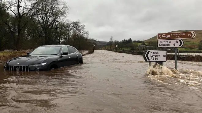 Cars struggle in deep flood waters near Appersett, North Yorkshire