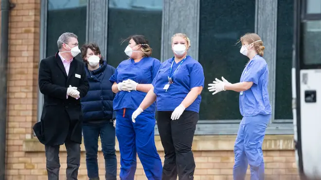 Nursing staff wait to greet people heading into quarantine in the UK