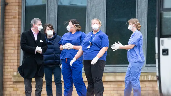 Medical staff wait to greet people heading into quarantine in the UK