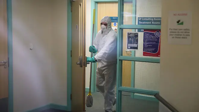 A man in protective clothing cleaning the County Oak Medical Centre GP practice in Brighton