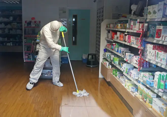 A cleaner in a hazmat suit disinfects a GP surgery in Brighton