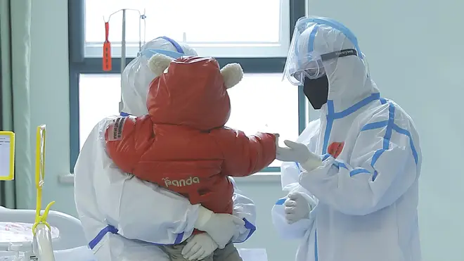 Medical staff tend to a baby infected with coronavirus