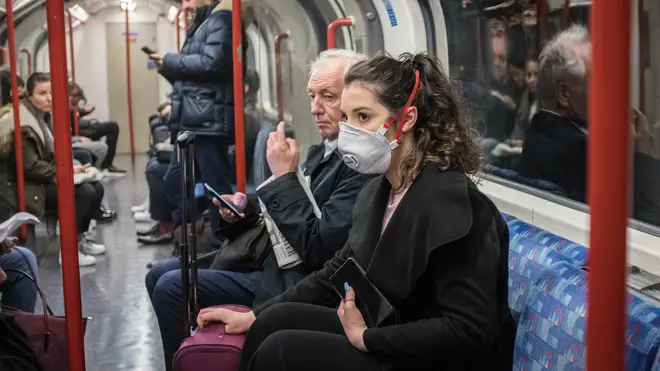 A woman seen on a tube wearing a face mask. A total of nine people in the UK are now being treated for COVID-19
