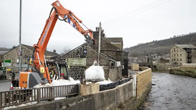 Workers construct flood defences in Mytholmroyd in the Upper Calder Valley in West Yorkshire