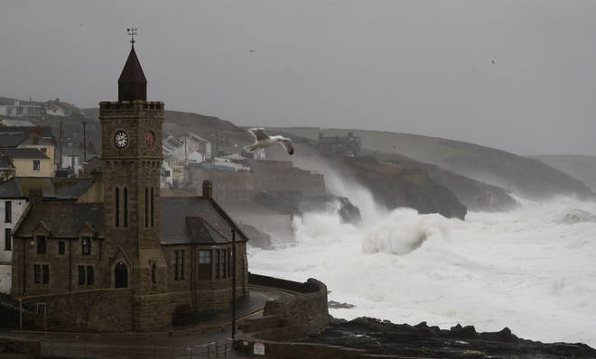 Powerful waves break on the shoreline around the small port of Porthleven, south west England