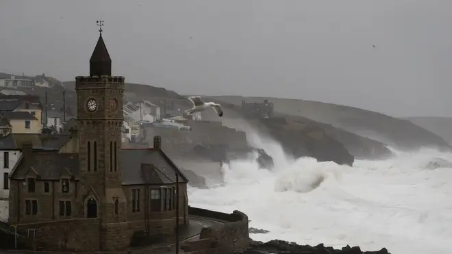 Powerful waves break on the shoreline around the small port of Porthleven, south west England