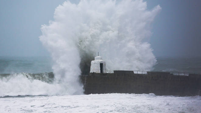 Waves pound against the harbour wall at Portreath, Cornwall