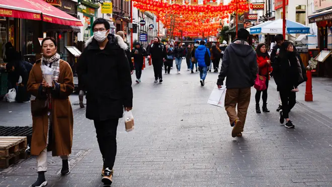 People wear medical face masks on Gerrard Street in Chinatown in London (file image)