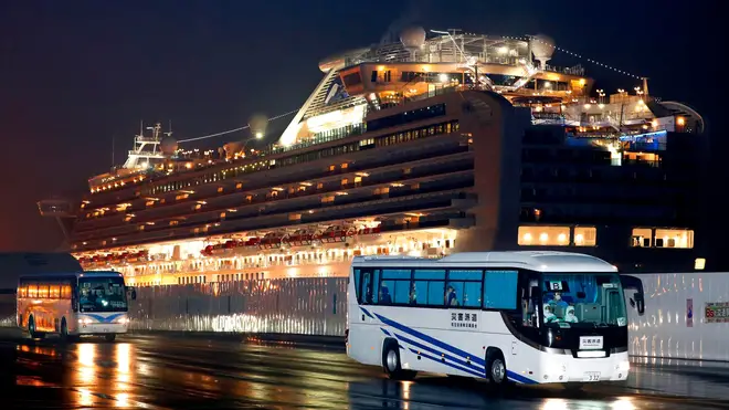 Buses carrying US passengers who were aboard the quarantined cruise ship leave the port