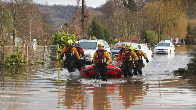 A care home resident is pulled to safety by rescue workers as floodwater surrounds the village of Whitchurch in Herefordshire